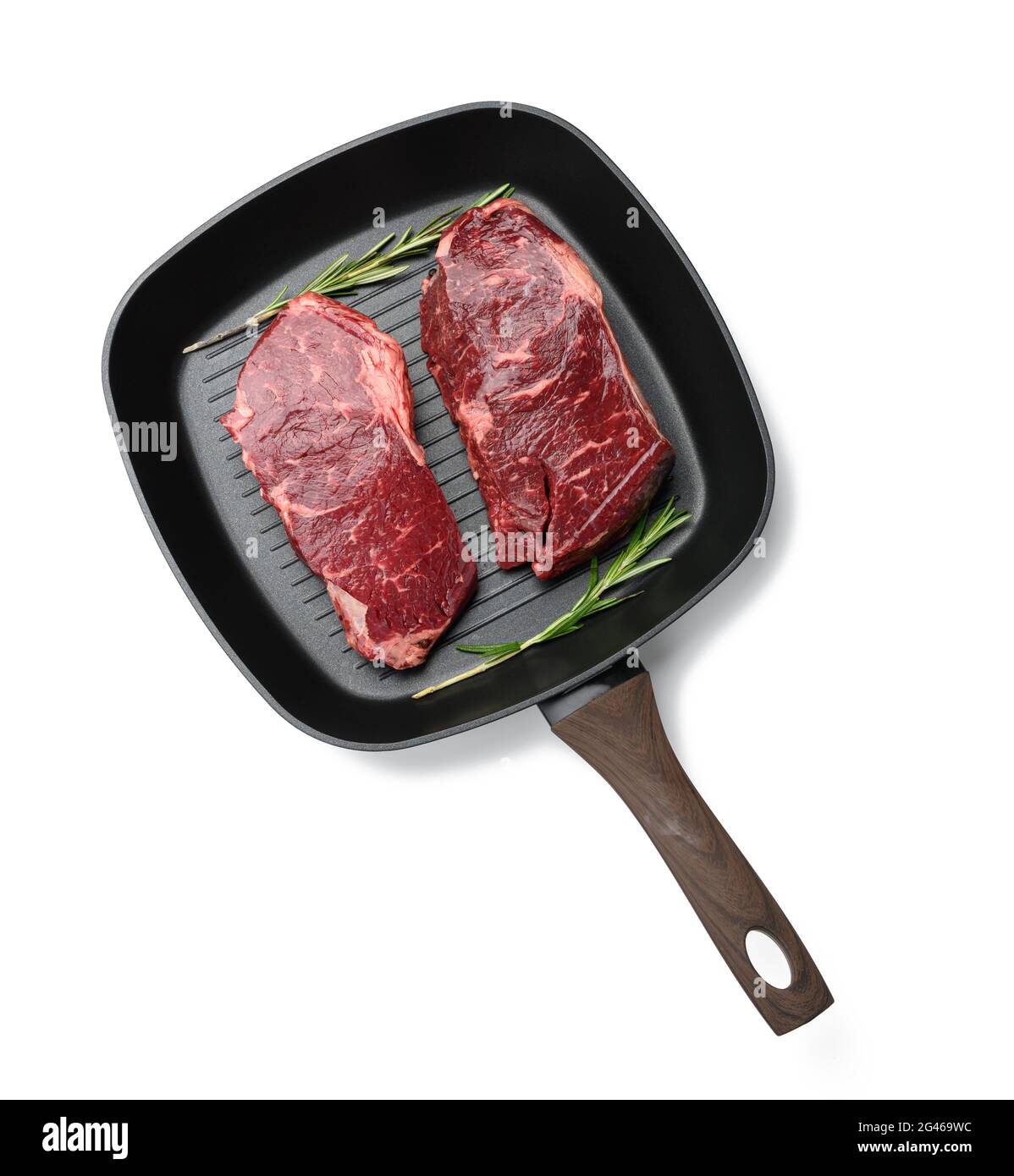 Zwei rohe Stücke Rindfleisch in einer schwarzen quadratischen Grillpfanne, Steaks isoliert auf weißem Hintergrund Stockfoto