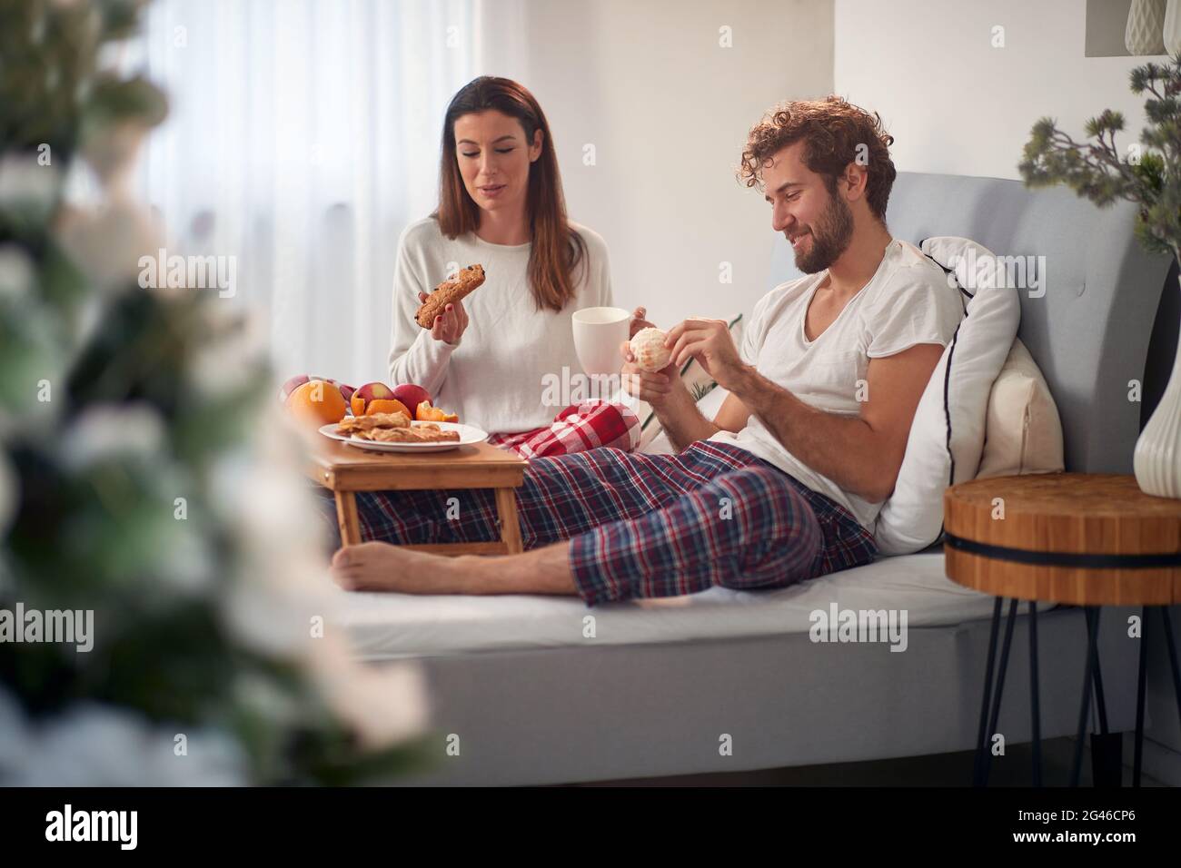 Junges erwachsenes Paar beim Frühstück im Bett Stockfoto