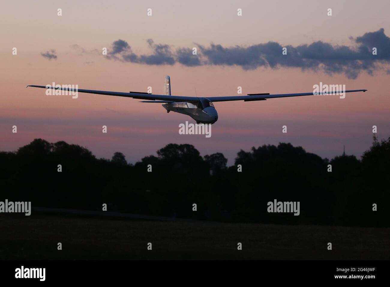 Düsseldorf, Deutschland. Juni 2021. Ein Segelflugzeug kehrt nach Sonnenaufgang zum Segelflugplatz Düsseldorf-Wolfsaap zurück. Bereits um 4.30 Uhr morgens waren sechs Segelflugzeuge vom Düsseldorfer Aero Club abgeheben, um den nahenden längsten Tag des Jahres mit „längsten Tagesflügen“ zu begrüßen. Kredit: David Young/dpa/Alamy Live Nachrichten Stockfoto