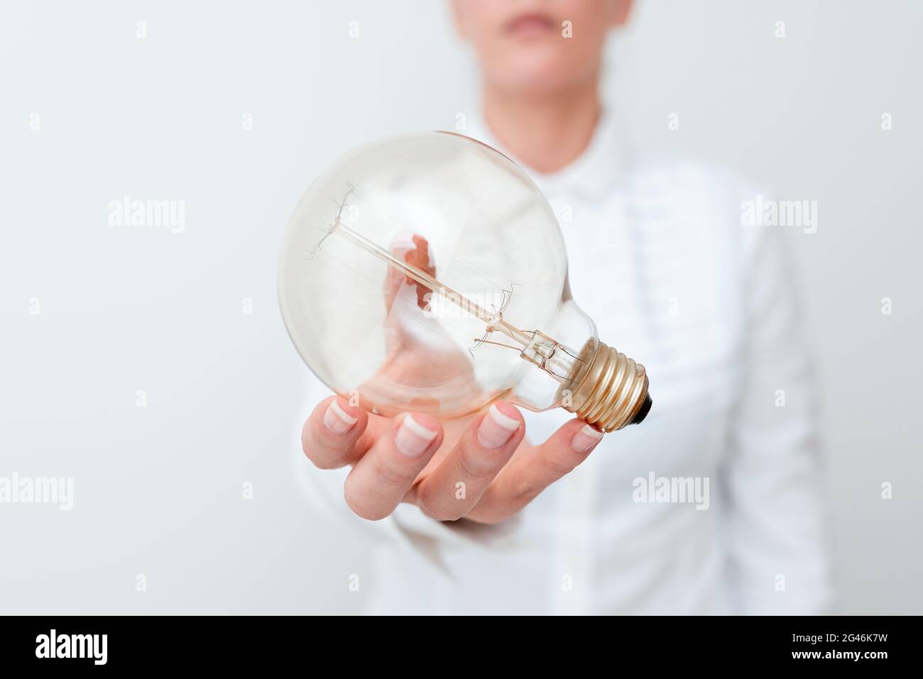 Lady Holding Lampe Mit Formellem Outfit Präsentiert Neue Ideen Für Das Projekt, Business Frau Zeigt Glühlampe Mit Einer Hand Ausstellen Neu Stockfoto