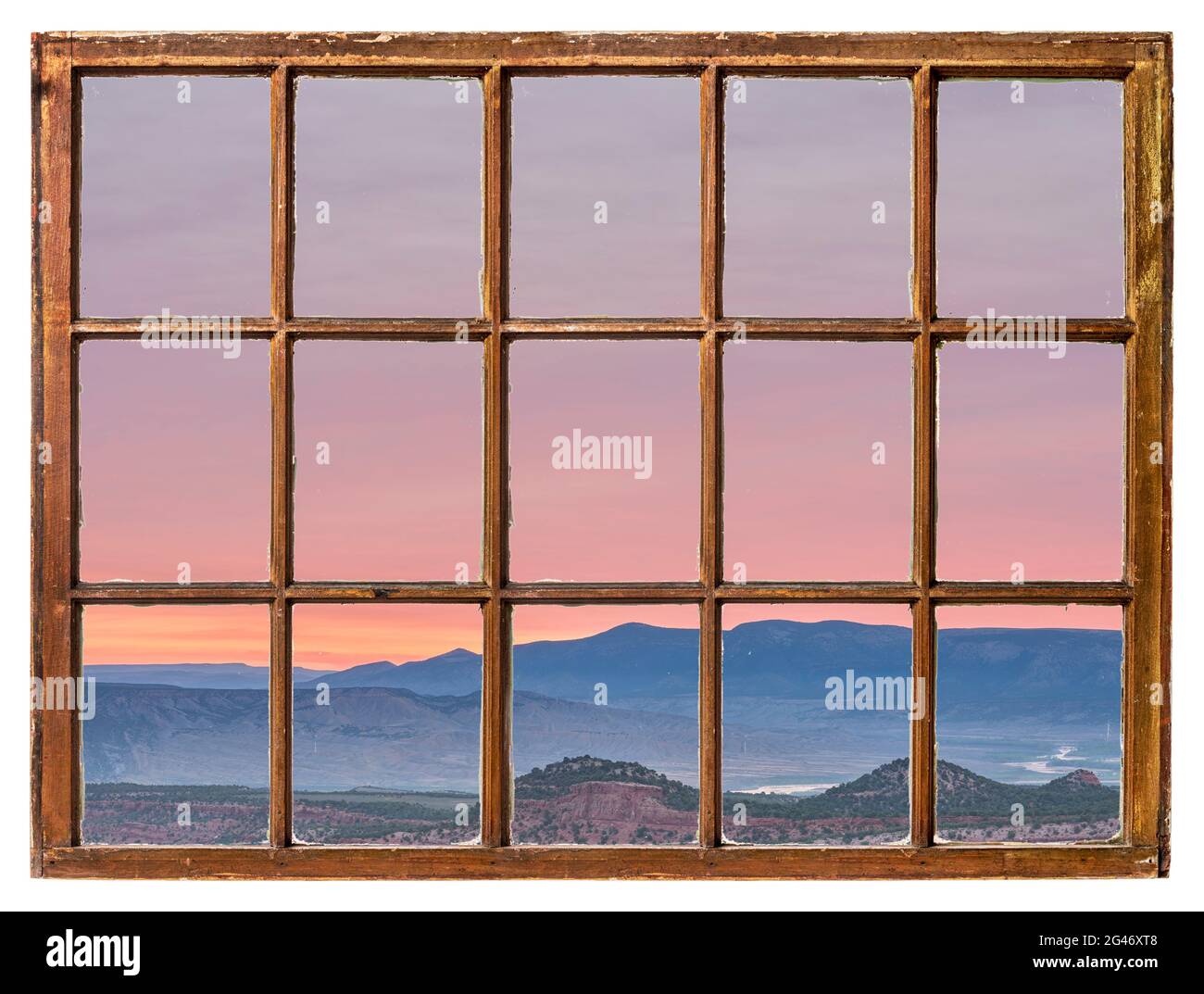 Farbenprächtiger Himmel bei Sonnenaufgang im Nordwesten Colorados, von einem alten Kabinenfenster aus gesehen Stockfoto
