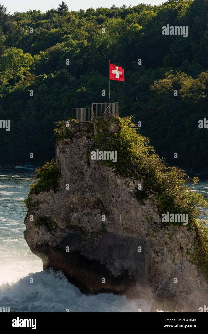 Schweizer Flagge auf einem Felsen mitten am rhein fällt bei Schaffhausen in der Schweiz 28.5.2021 Stockfoto