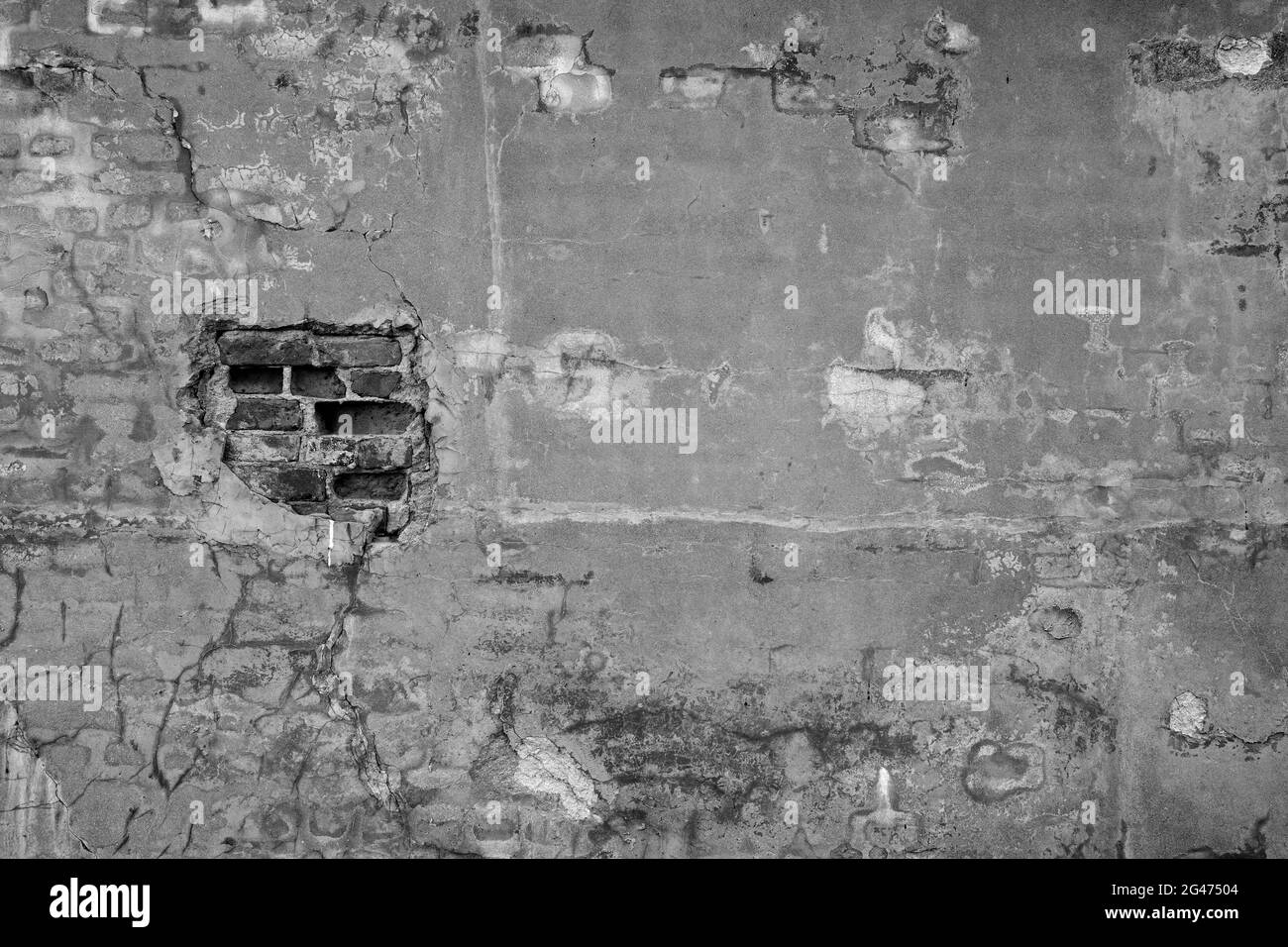 Vorderansicht einer alten, schmutzigen, beschädigten und verputzten Wand. Der Putz ist teilweise abgeschält und zeigt alte Ziegelsteine. Hochauflösender texturierter Hintergrund im Vollformat Stockfoto