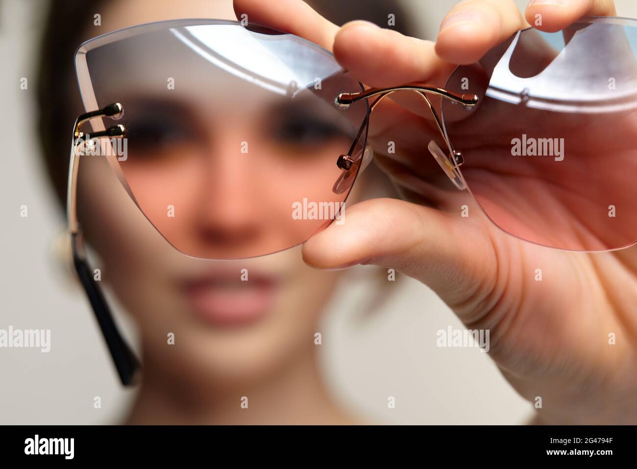 Das Weibchen schaut durch eine Brille auf die Kamera. Stockfoto