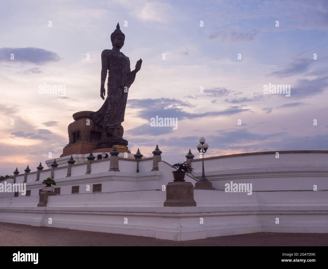 Grand Walking buddha Bronzestatue ist die Hauptstatue in Phutthamonthon (buddhistische Provinz) in Nakornpathom, Thailand, in der Dämmerung Stockfoto