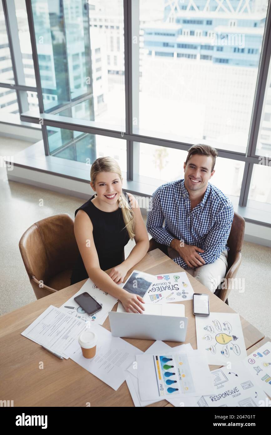 Overhead-Ansicht von Führungskräften, die am Schreibtisch einen Laptop verwenden Stockfoto