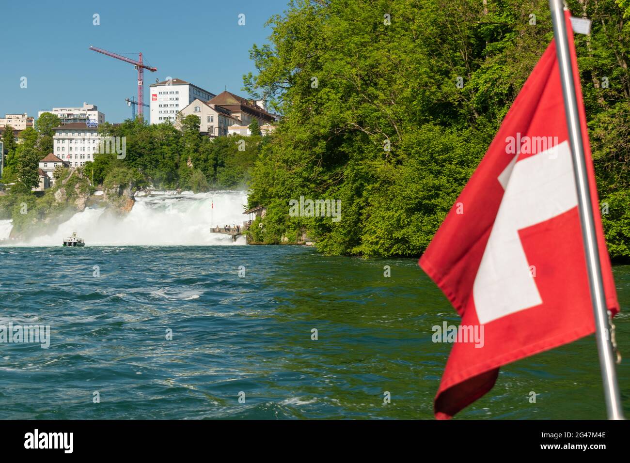 Die Schweizer Flagge schwenkt im Wind während einer Bootstour an den beliebten rheinfällen in der Schweiz 28.5.2021 Stockfoto