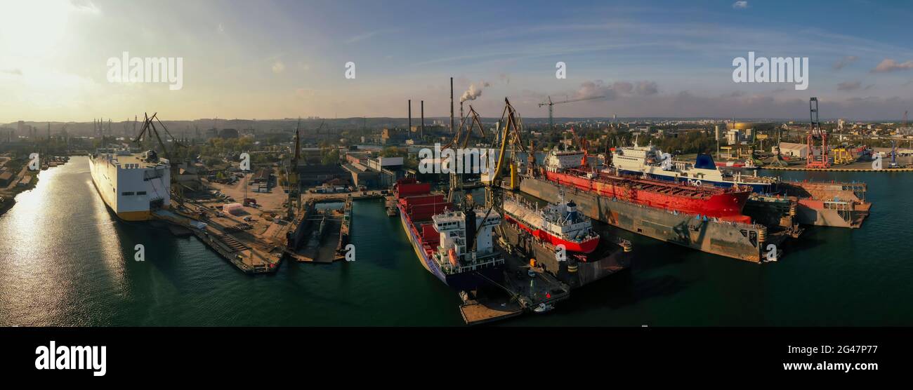Schönes Sonnenuntergangspanorama Remontova Werft mit Schiffen in Trockendocks. Polen, Danzig, Drohnenaufnahmen, Tageslicht. Stockfoto