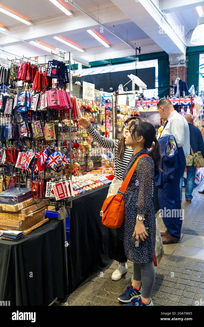 Asiatische Frauen, die im Jubilee Market, Covent Garden, London, Großbritannien, Souvenirs kaufen Stockfoto