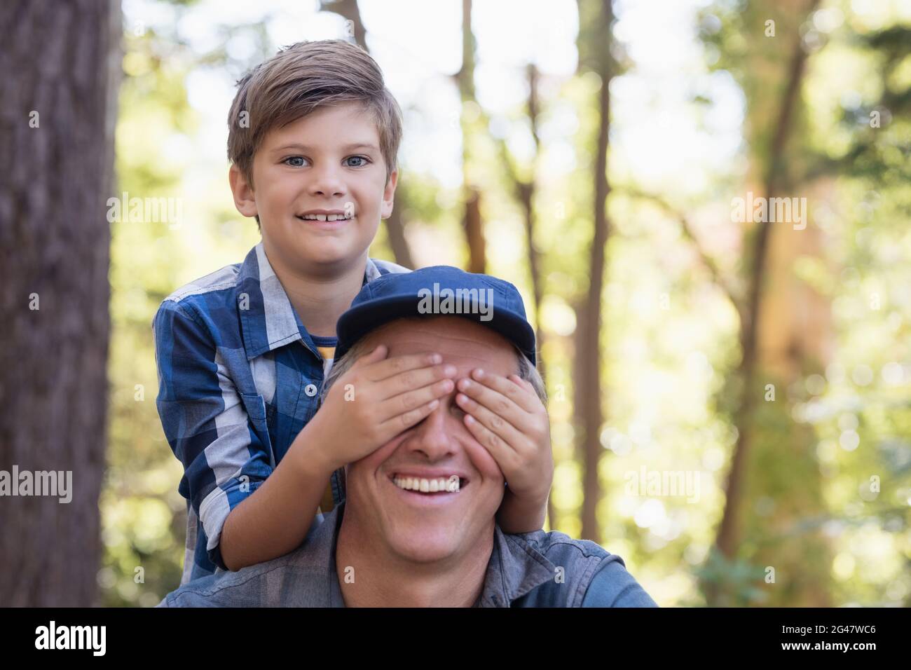 Porträt eines Jungen, der die Augen des Vaters bedeckt Stockfoto