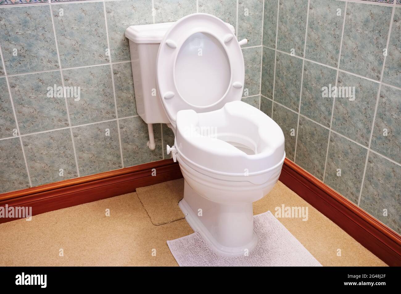 Toilette mit Höhenverlängerung für behinderte Senioren im Haus Stockfoto