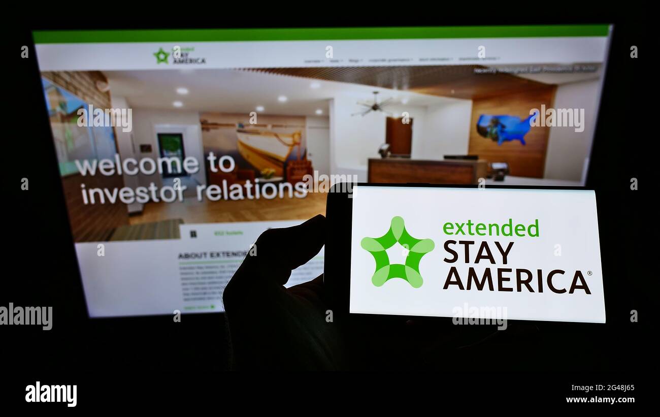 Person, die das Smartphone mit dem Logo der US-Apartmenthotelkette Extended Stay America Inc. Auf dem Bildschirm vor der Website hält. Konzentrieren Sie sich auf die Telefonanzeige. Stockfoto