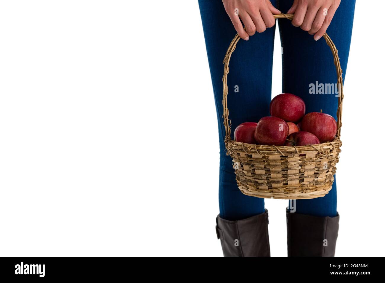 Mittelteil einer Frau, die Äpfel in einem Korbkorb hält Stockfoto