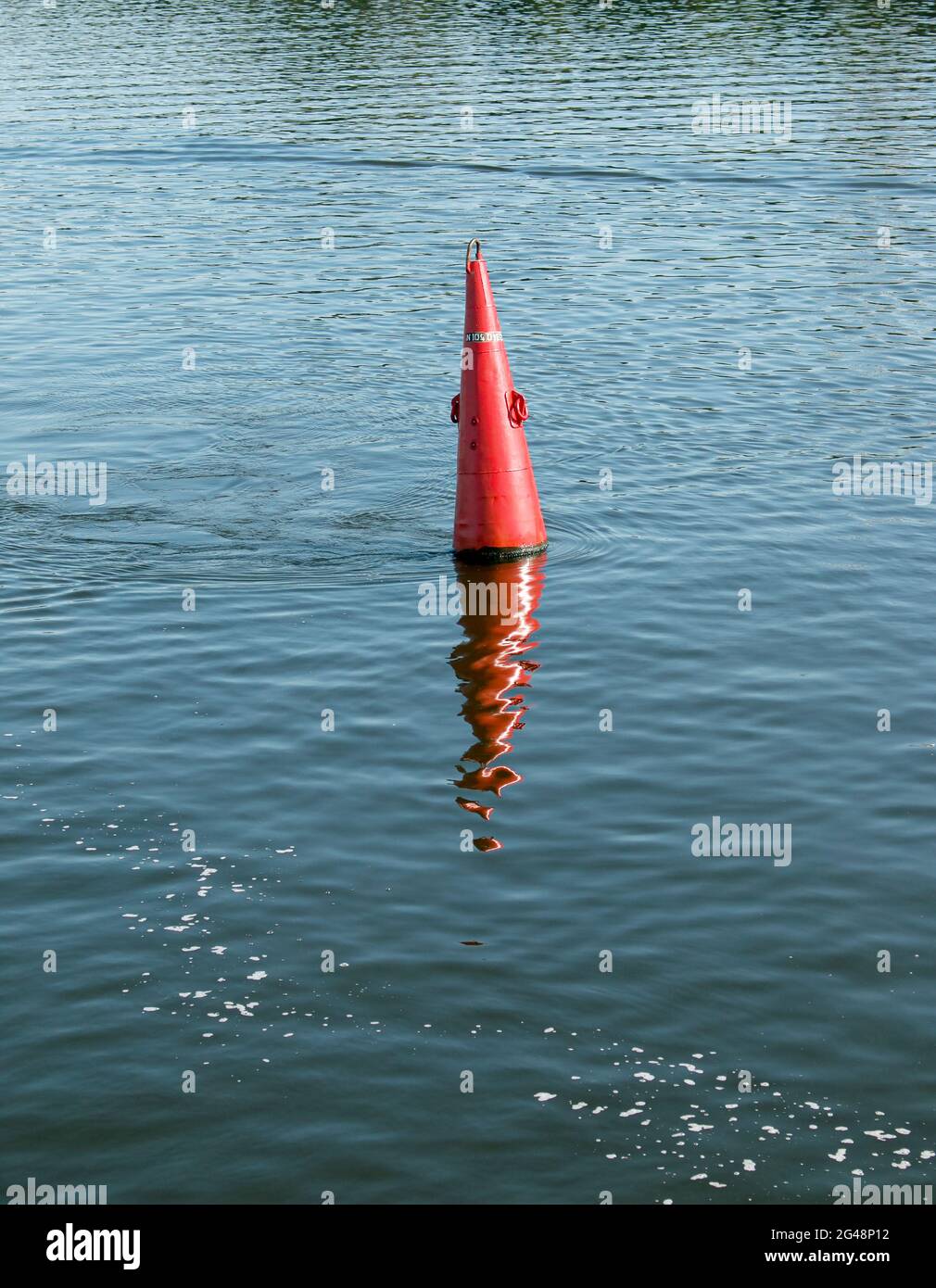 Schwimmende rote Navigationsboje auf blauem Wasser des Dnipro River. Boje im Fluss. Navigationsausrüstung. Ruhige Wasseroberfläche. Stockfoto