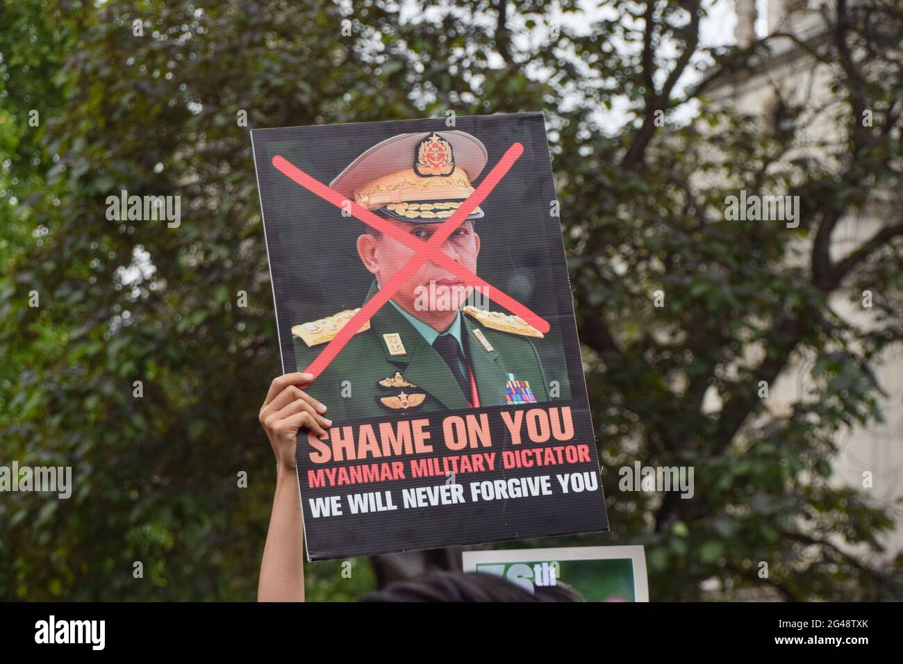 London, Großbritannien. Juni 2021. Ein Protestler hält während der Anti-Putsch-Demonstration ein Plakat gegen Gen Min Aung Hlaing auf dem Parliament Square. Demonstranten aus Myanmar marschierten gegen den Militärputsch am Geburtstag von Aung San Suu Kyi durch das Zentrum von London. Kredit: SOPA Images Limited/Alamy Live Nachrichten Stockfoto