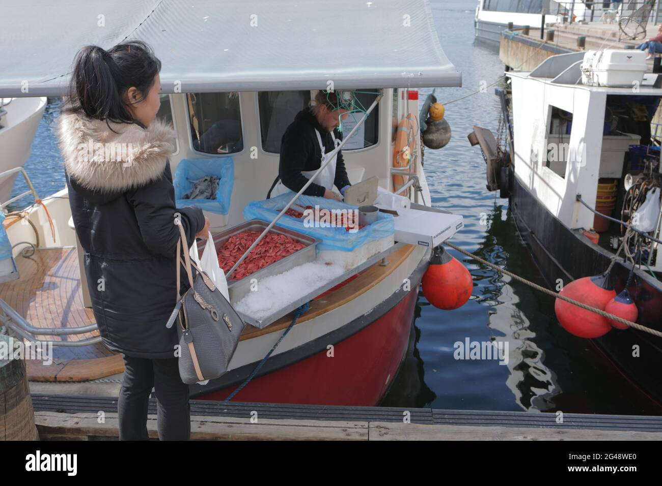 Menschen, die Fisch an Fischerbooten auf Rådhusbrygge, dem Rathausplatz in Oslo, Norwegen, kaufen Stockfoto