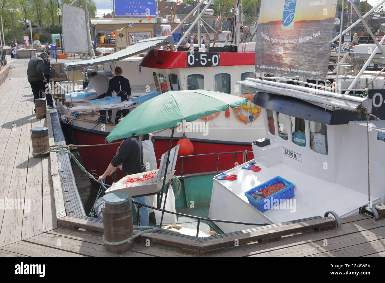 Menschen, die Fisch an Fischerbooten auf Rådhusbrygge, dem Rathausplatz in Oslo, Norwegen, kaufen Stockfoto