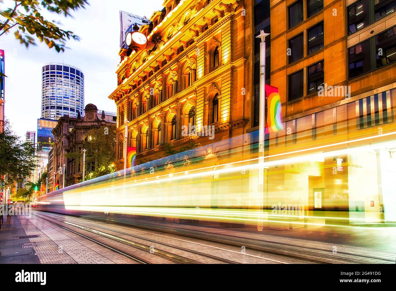 George Street in der Innenstadt von Sydney CBD, die den Martin Place mit der verschwommenen Straßenbahn kreuzt. Stockfoto