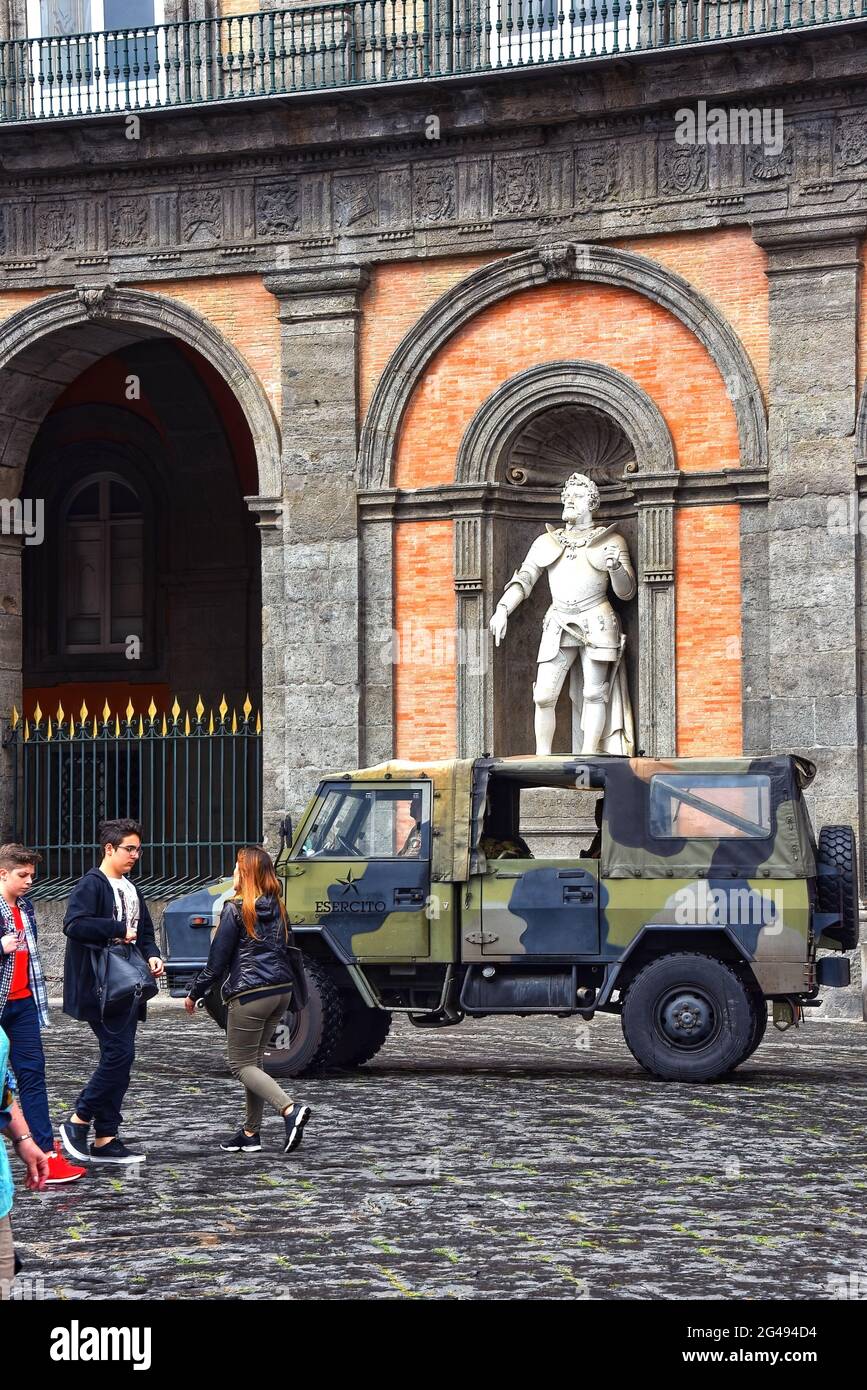 Neapel, Italien - 8. Mai 2018: Ein Jeep der italienischen Armee fährt an einer Statue des ehemaligen Königs Carlo V eines der ehemaligen Könige von Neapel im Palazzo vorbei Stockfoto