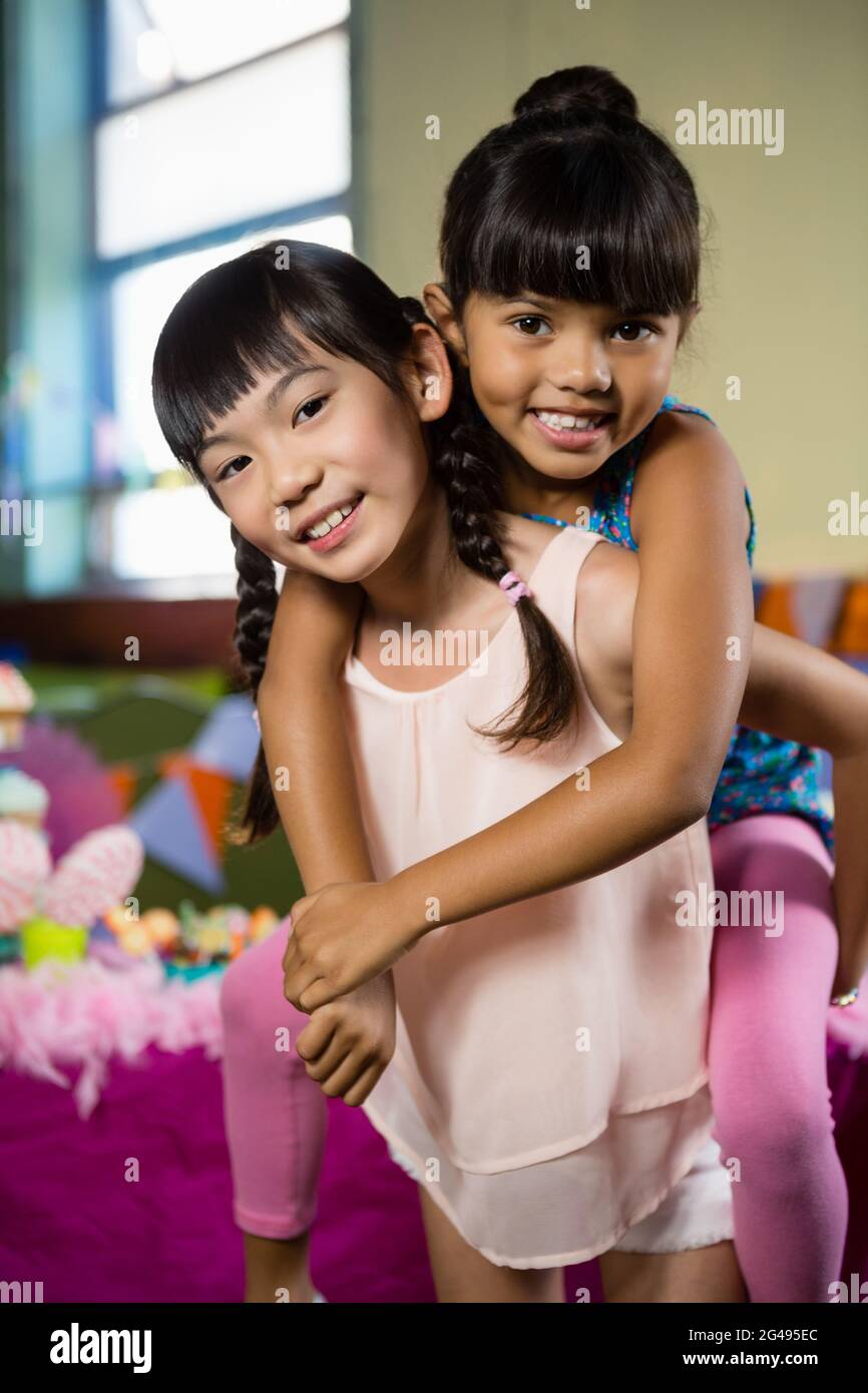 Mädchen geben Huckepack Fahrt zu ihrem Freund während der Geburtstagsparty Stockfoto