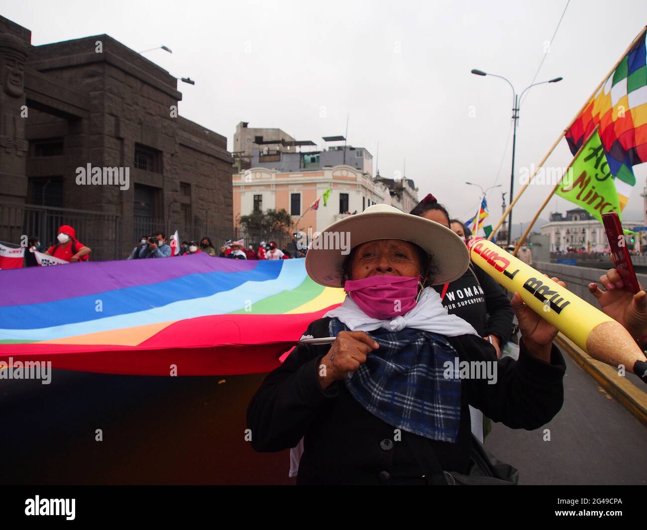 Eine indigene Frau, die eine riesige Regenbogenfahne trug, als Tausende auf die Straße gingen und die Anerkennung von Pedro Castillo als Sieger der Präsidentschaftswahl forderten. Stockfoto