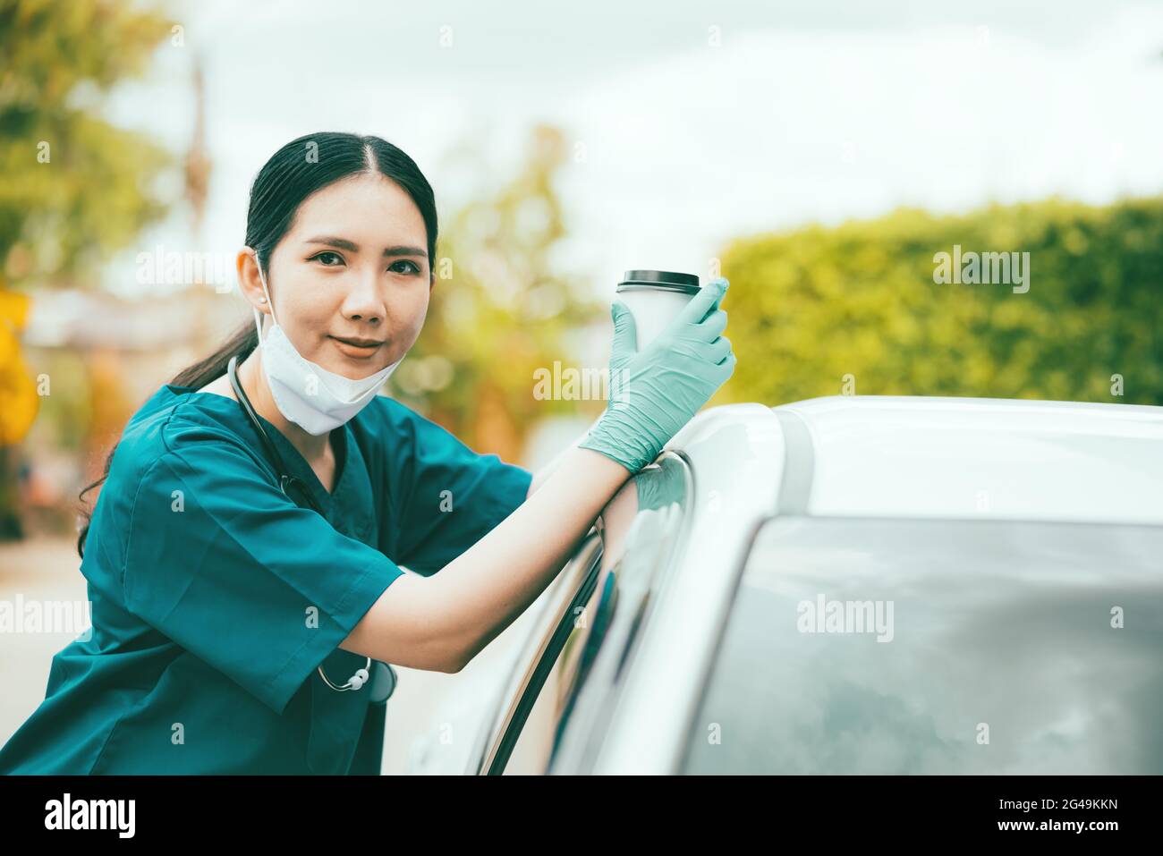 Porträt einer müden, erschöpften Krankenschwester oder eines Arztes, die morgens eine Kaffeepause draußen machte. COVID-19, Coronavirus-Pandemie Stockfoto
