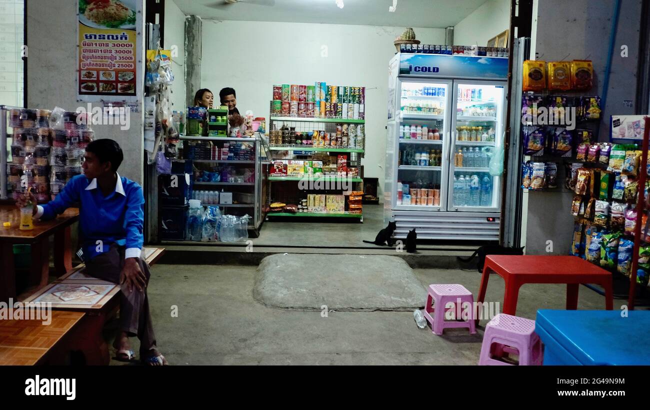 Essen und Getränke Imbiss 24-Stunden-Geschäft in der Nacht Bangkok Thailand Mann und Frau hinter dem Tresen und Mann am Tisch sitzen Stockfoto