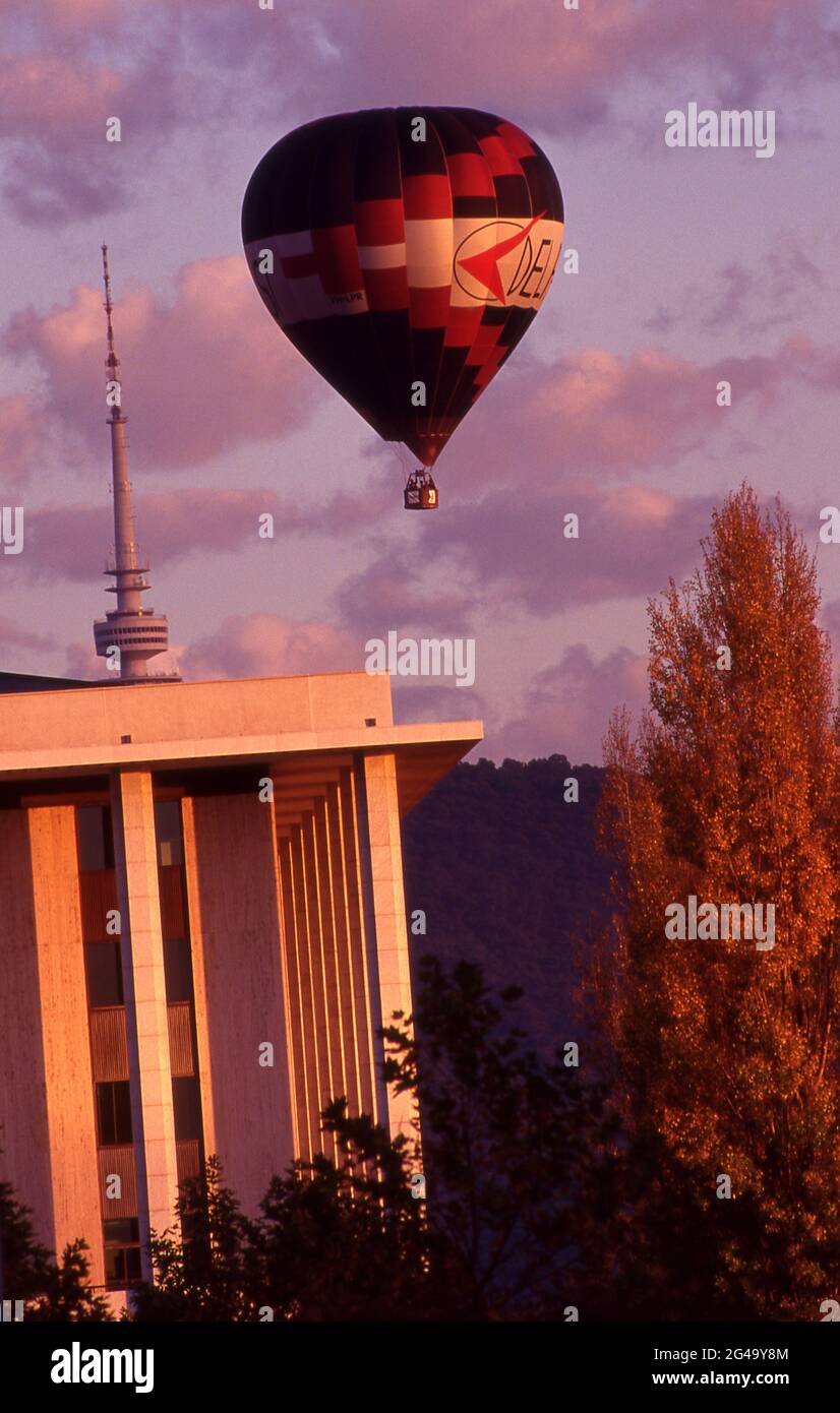 HEißluftballon fliegt über Canberra, Telstra-Turm im Hintergrund und ein Abschnitt der Bibliothek in F/G. Australisches Hauptstadtterritorium. Stockfoto