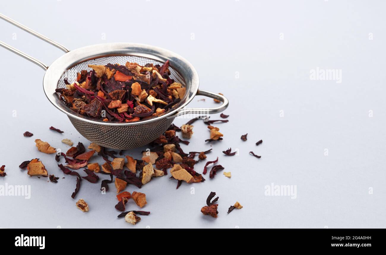Teesieb mit Teeblättern und Früchten und Beeren Stockfoto