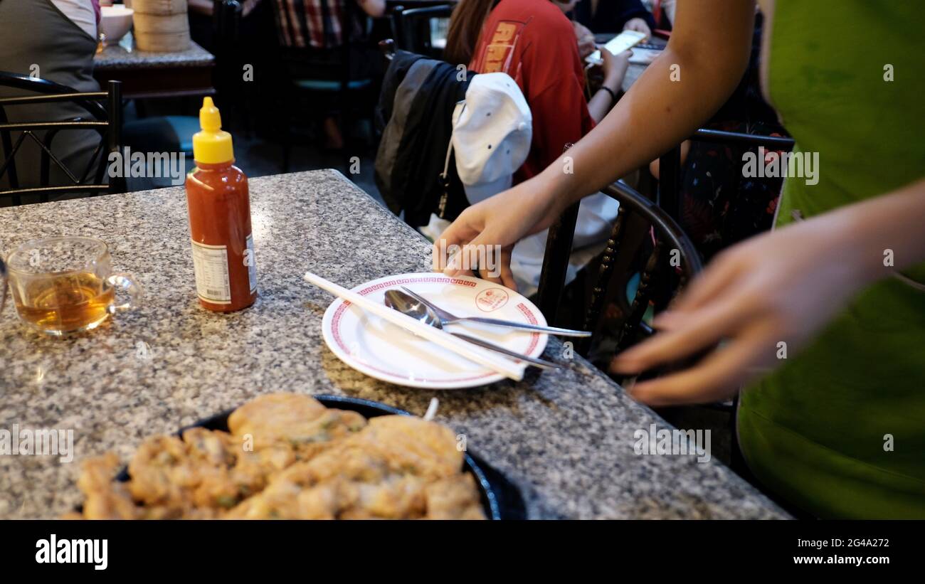 Essen gastfreundlich im Restaurant in Chinatown Bangkok Thailand Essen auf dem Teller gebratene Austern Kellnerin am Arbeitsplatz Reinigungstisch Stockfoto