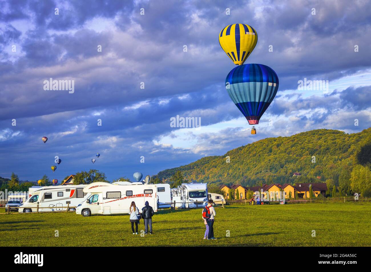 Spektakuläre bunte Heißluftballons bei Sonnenaufgang über dem Campingplatz. Erholungsfahrzeug rv Reise, Wohnwagen und Campingplatz, Familienurlaub und Outdoo Stockfoto
