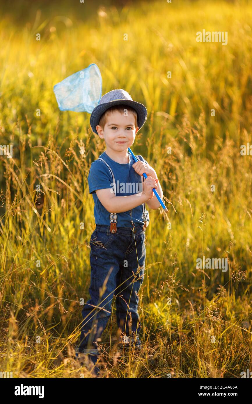 Porträt eines kleinen glücklichen Jungen im Hut mit Schmetterlingsnetz Stockfoto