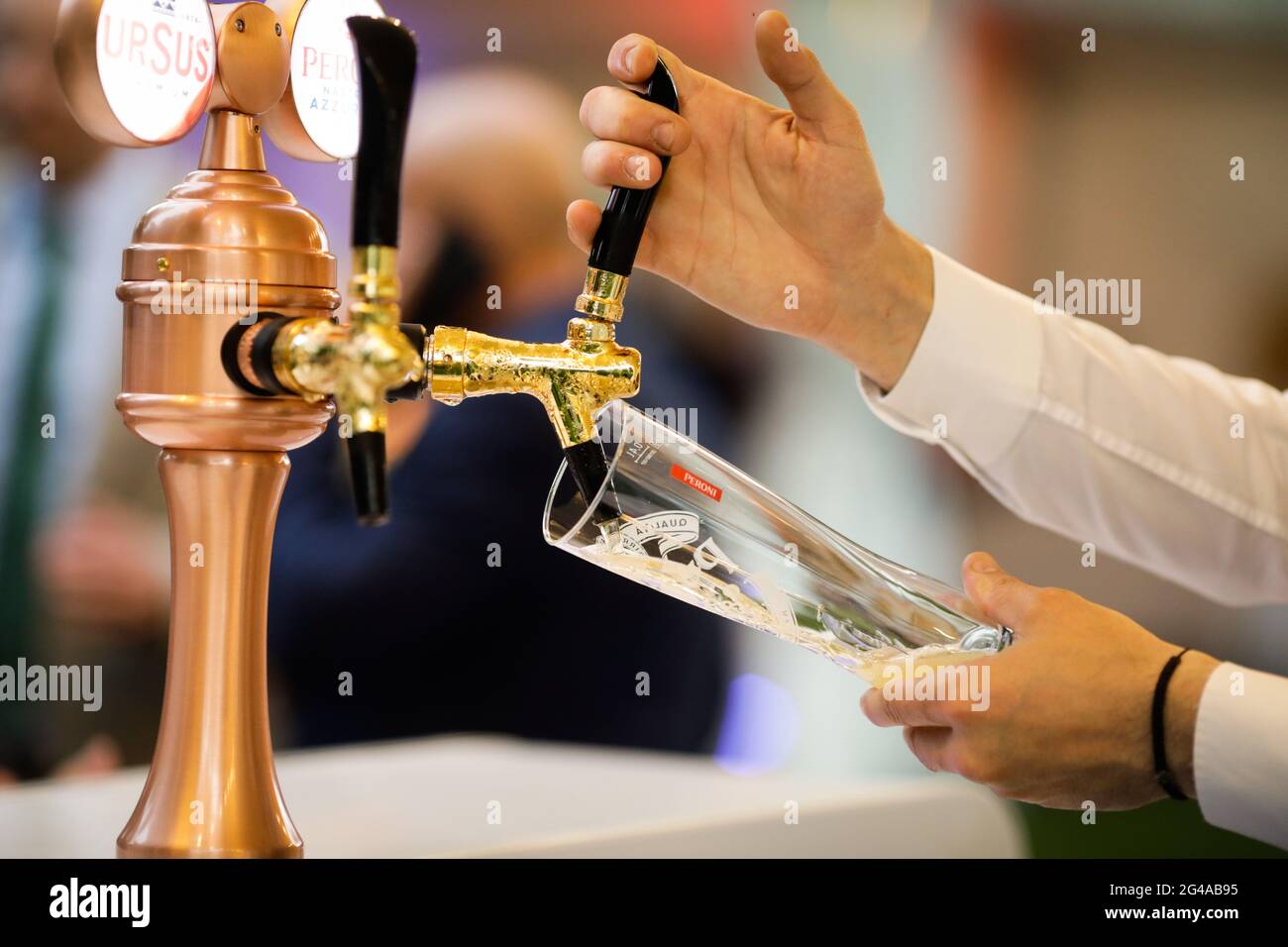 Bukarest, Rumänien - 17. Juni 2021: Details zur geringen Schärfentiefe (selektiver Fokus) bei einem Mann, der an einer Bar Peroni-Bier in ein Glas gießt. Stockfoto
