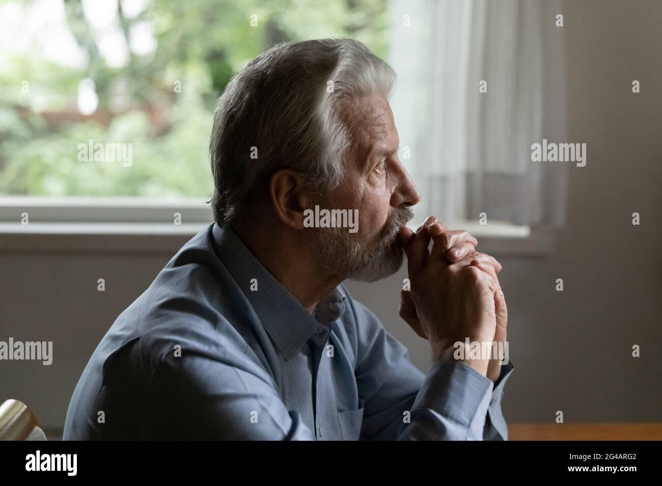 Trauriger älterer Mann schaut in der Ferne und fühlt sich einsam deprimiert Stockfoto