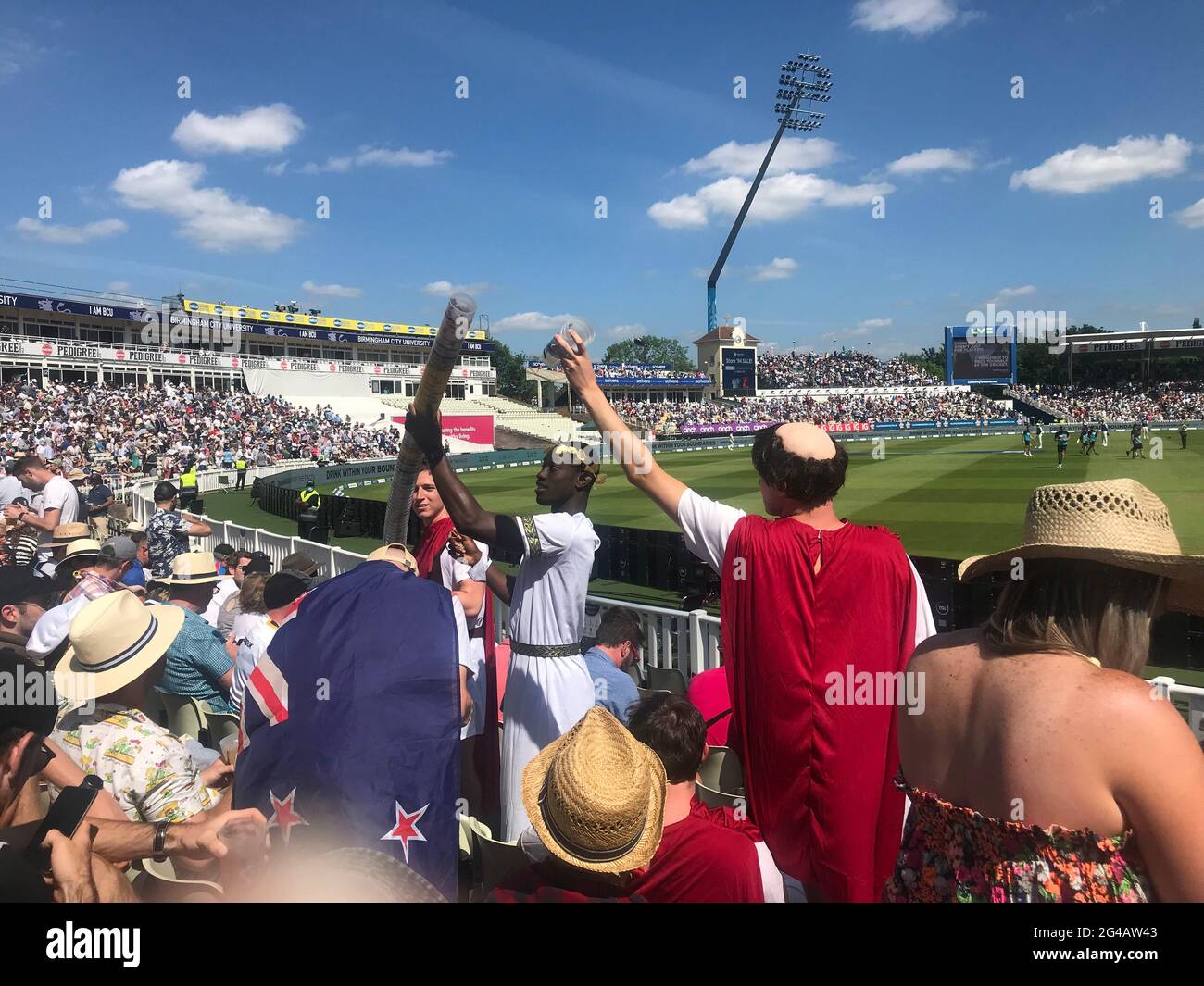 Menschenmengen, die sich bei einem Cricket-Spiel beim Bau einer Plastikbierschlange amüsieren. Ein beliebter Zeitvertreib am Nachmittag, wenn der Alkohol zu fließen beginnt. Stockfoto