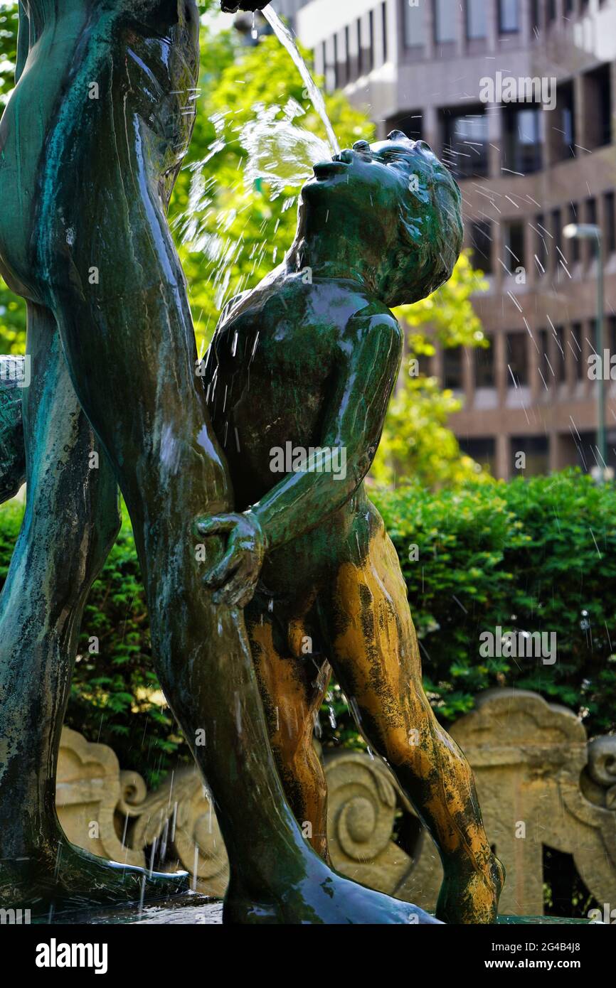 Die Neckerei-Brunnen, die zwei spielende Kinder zeigt, ist eine historische Bronzeskulptur mit Wasserbrunnen des Bildhauers Gregor von Bochmann, die 1909 errichtet wurde. Stockfoto