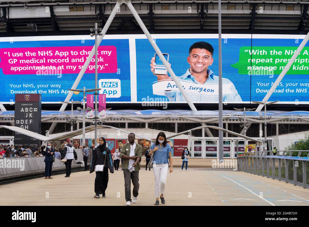Covid-19 Impfzentrum im Olympiastadion Stratford, East London, England, glücklich geimpfte Menschen kommen aus der Pop-up-Klinik Stockfoto