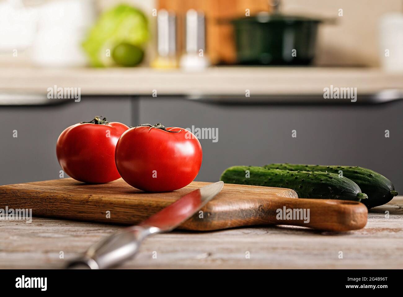 Nahaufnahme reifer Tomaten auf einem Schneidebrett. Küchenzubehör. Schneiden von Holzbrettern und Utensilien. Frisches und leckeres Gemüse. Gezüchttes organisches Produkt Stockfoto