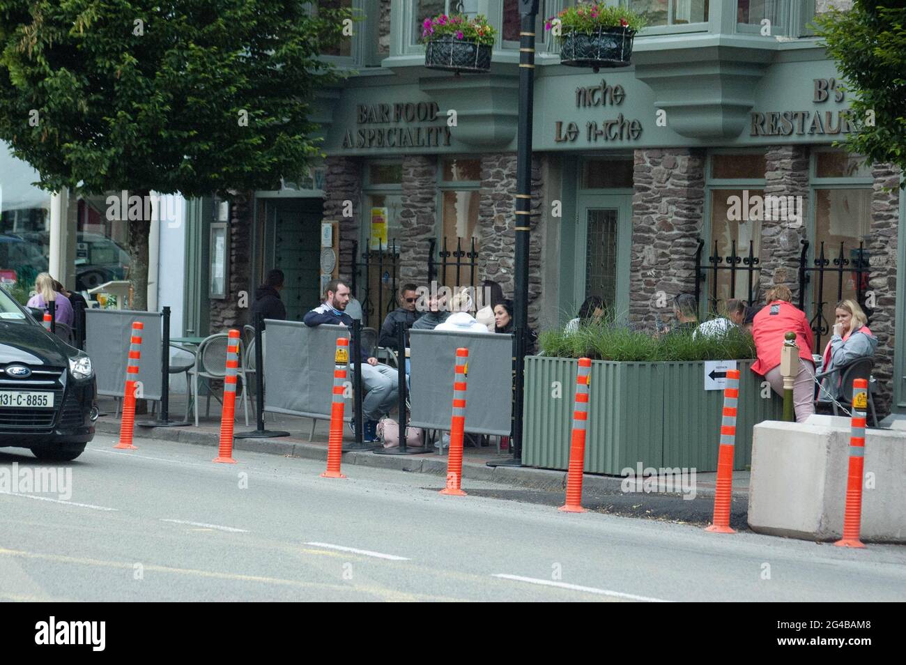 Macroom Co. Cork, Irland, Sonntag, 20. Juni 2021; nach monatelangen Schließungen hat das Essen im Freien wieder aufgenommen. Macroom-Unternehmen wie das Castle Hotel an der Hauptstraße von Cork Town freuten sich über die Wiedereröffnung. Sie erinnern jedoch immer noch daran, dass das Tragen von Gesichtsmaschen und das Halten von 2 Metern Abstand immer noch obligatorisch sind und dass nur Außenbereiche geöffnet sind. Die nächste Phase der Wiedereröffnung ist am 5. Juli, wenn der Innendienst wieder aufgenommen werden kann. Credit ED/Alamy Live News Stockfoto