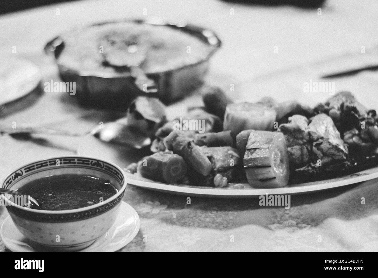 Essen am Tisch, exotisches Essen am Tisch bedeutet gesellschaftliche Veranstaltungen und Zusammenkünfte der Menschheit. Schwarzweiß-Food-Fotografie Stockfoto