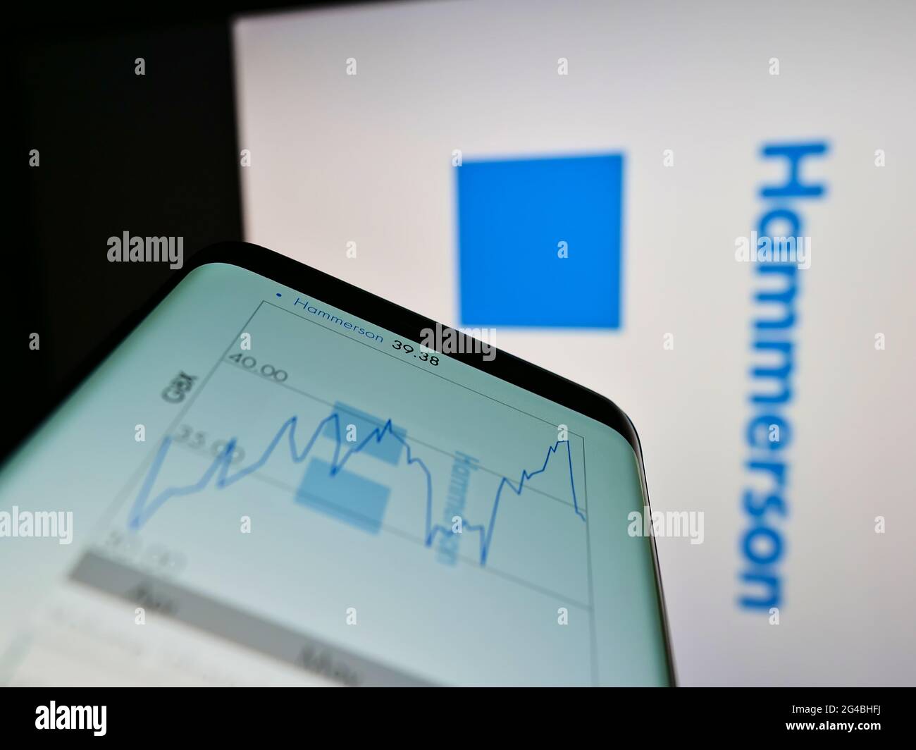 Person mit Mobiltelefon und Webseite des britischen Immobilienentwicklungsunternehmens Hammerson plc auf dem Bildschirm mit Logo. Konzentrieren Sie sich auf die Mitte des Telefondisplays. Stockfoto