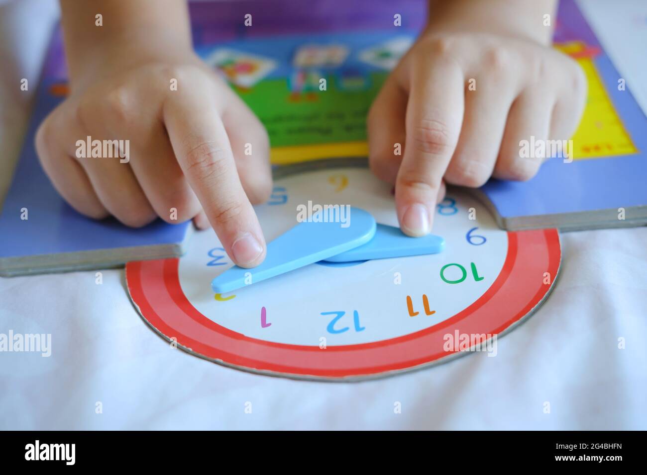 Kind spielen sagen Zeit Spiel, kleine Kinder zu lernen, wie man eine analoge Uhr zu lesen. Stockfoto
