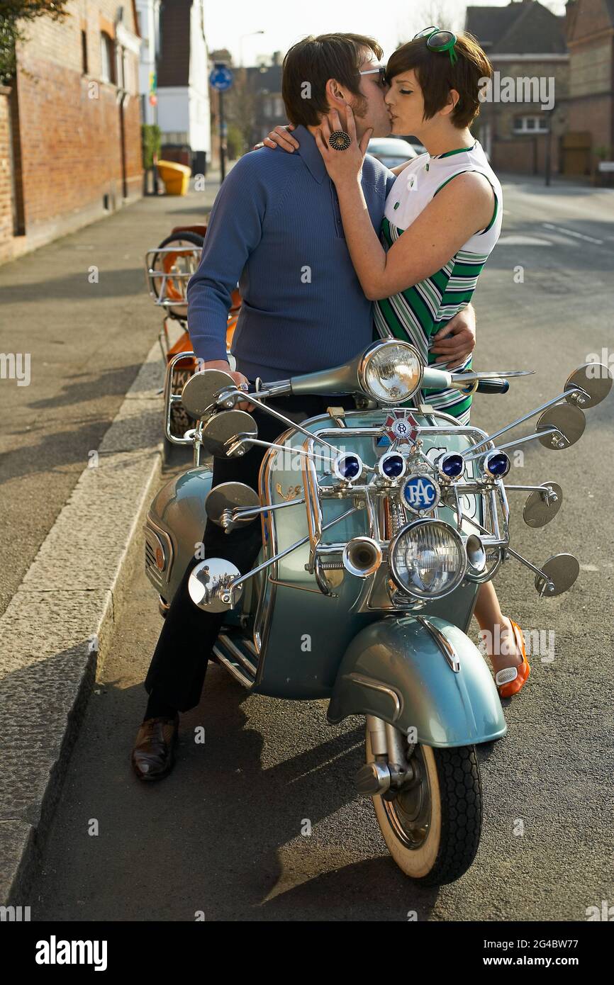 Küssen junges Paar mit Roller in London, Großbritannien Stockfoto