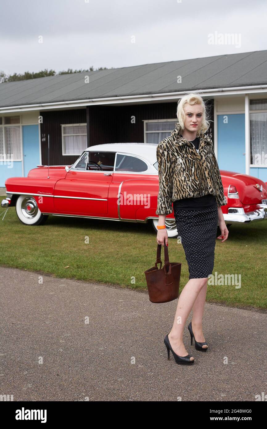 GROSSBRITANNIEN / England /Norfolk /Hemsby Rock 'N' Roll Weekender. Junge Frau, die vor einem roten cadillac posiert. Stockfoto