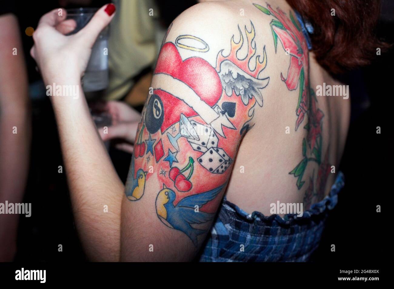 GROSSBRITANNIEN / England / London/ Nahaufnahme eines Mädchens mit Tattoos, das im Nachtclub mit einem Drink tanzt. Stockfoto