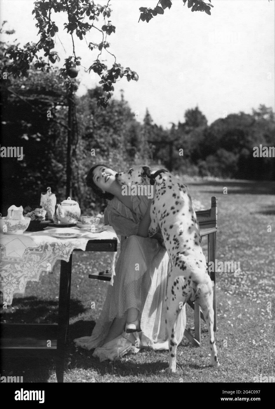 JESSIE MATTHEWS 1936 ehrliches Porträt mit dalmatinischem Hund im Garten von OTTO DYAR Werbung für Gaumont British Picture Corporation Stockfoto