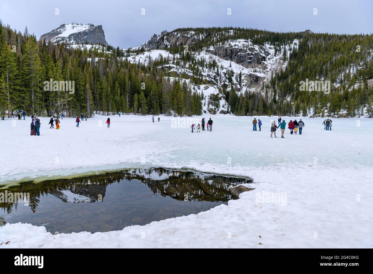 Frühling am Bear Lake - Es ist Frühling; Touristen genießen es auf dem noch gefrorenen und schneebedeckten Bear Lake im Rocky Mountain National Park, CO, USA. Stockfoto
