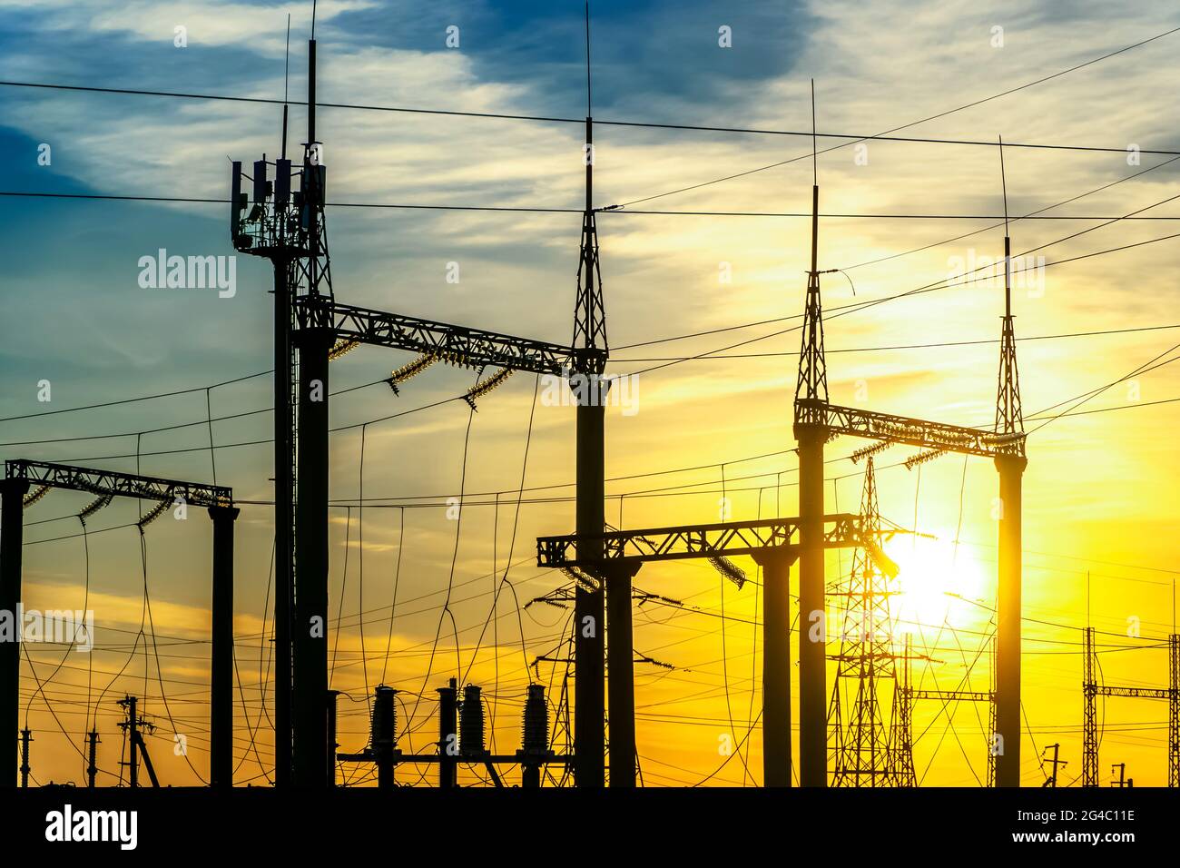 Produktion von Kraftstoff und Strom.Elektrische Netze mit Drähten und Transformatoren bei Sonnenuntergang.Stromübertragungsleitungen und aus dem Kraftwerk.Leistung l Stockfoto