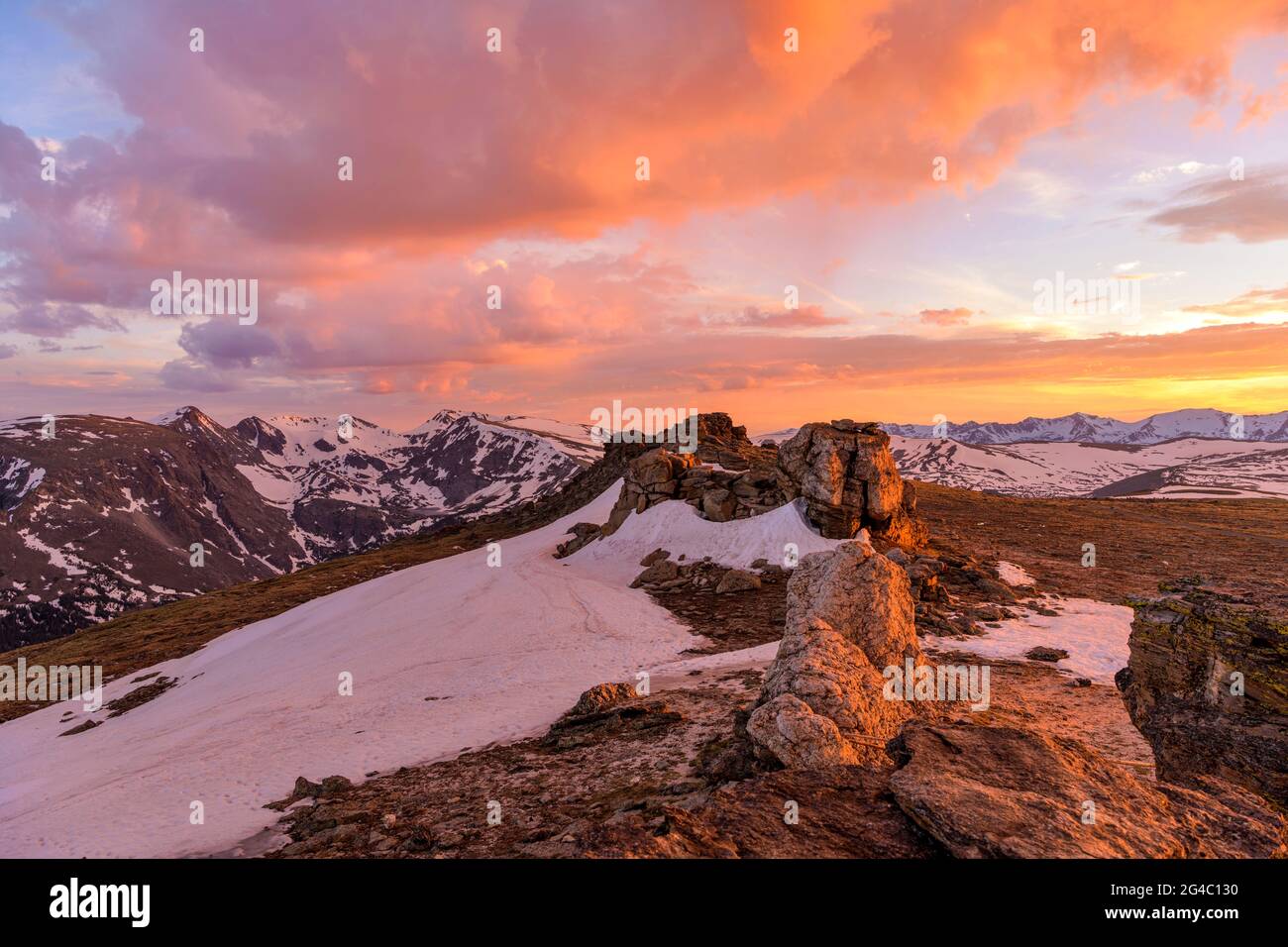 Sunset Mountain Top - farbenfrohe Frühlingswolken hängen über schneebedeckten hohen Gipfeln der Kontinentalscheide oben auf dem RMNP, Colorado, USA. Stockfoto