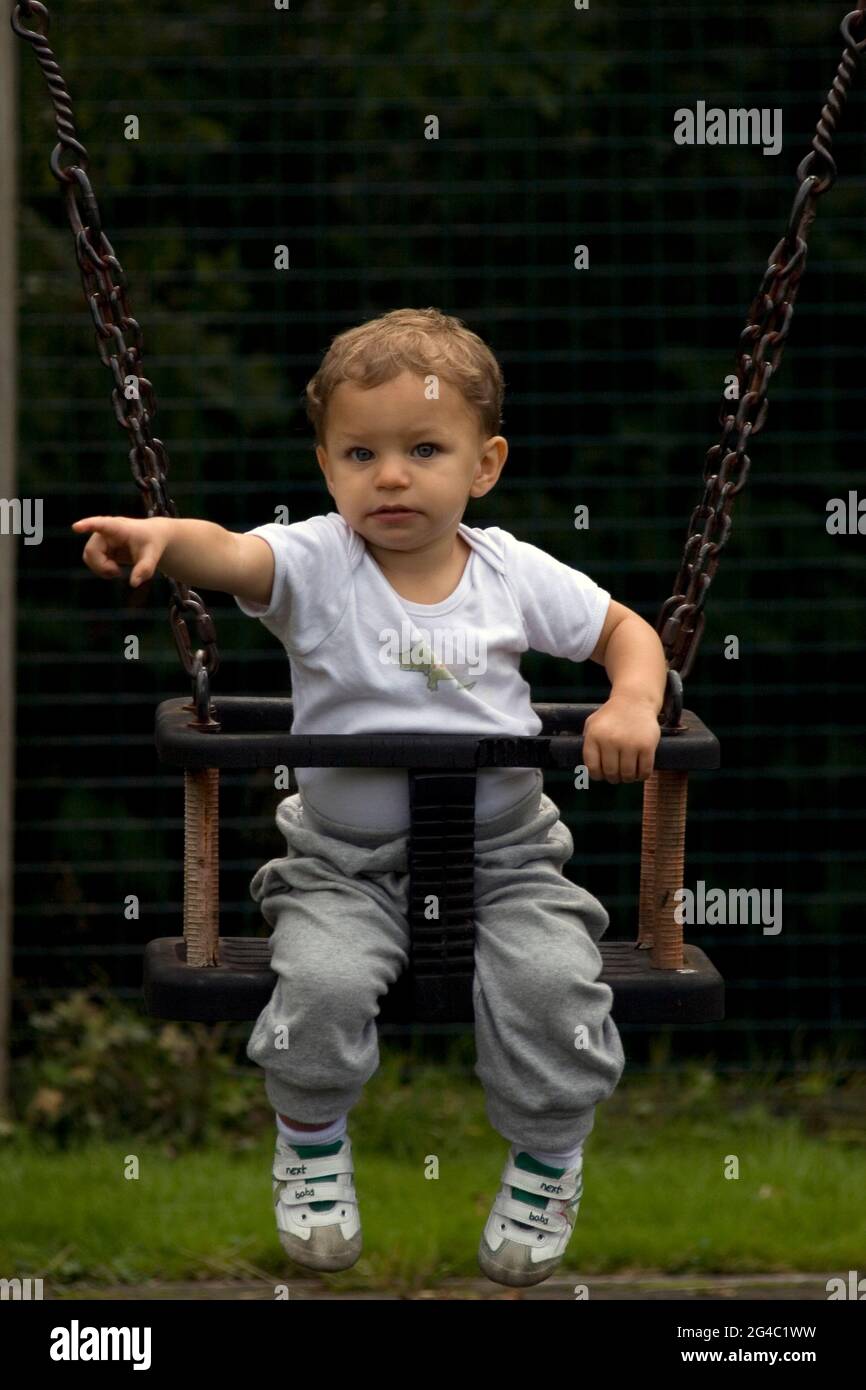 Kleiner Kleinkind Junge auf Schaukel im Park zeigt Stockfoto